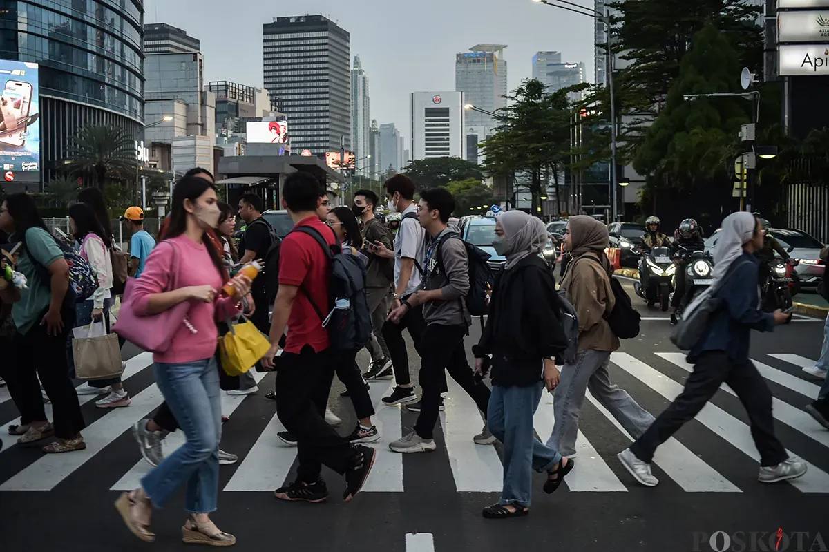 Para pekerja berjalan melintasi pedestrian saat jam pulang kerja di kawasan Jalan Jenderal Sudirman, Jakarta, Rabu, 22 Januari 2025. (Sumber: Poskota/ Bilal Nugraha Ginanjar)