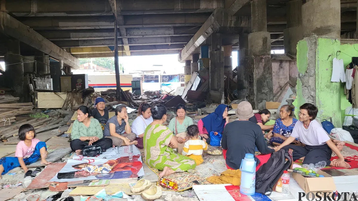 Warga kampung Tongkol Dalam yang masih bertahan di kolong tol Wiyoto Wiyono saat menerima relawan yang akan memberikan pelajaran les di bawah jembatan di Ancol, Pademangan, Jakarta Utara, Jumat (24/1). (Sumber: Poskota/ Pandi Ramedhan)