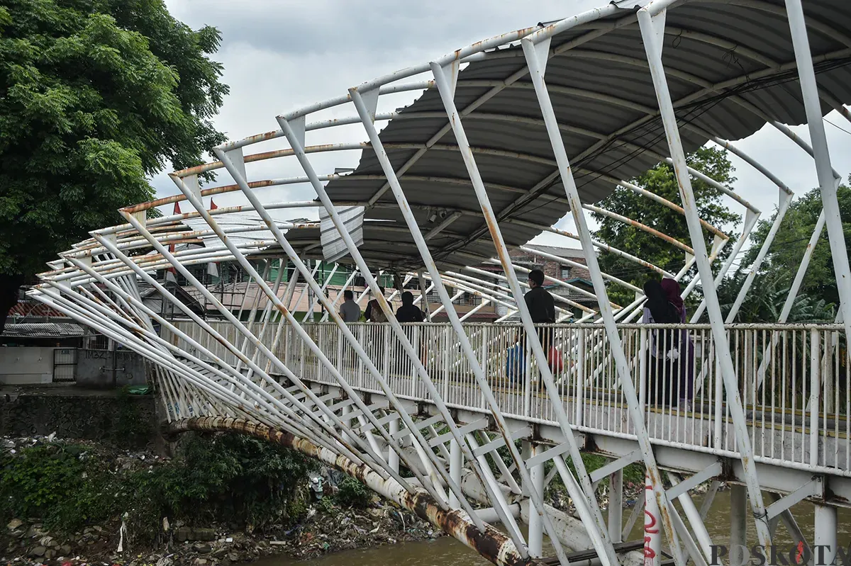 Warga melintasi Jembatan Penyebrangan Orang (JPO) Jayakarta di Manggarai, Jakarta, Senin, 27 Januari 2025. (Sumber: Poskota/Bilal Nugraha Ginanjar)