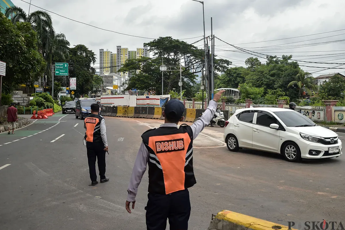 Petugas Dinas Perhubungan (DISHUB) DK Jakarta mengatur laju kendaraan saat melintas di kawasan Terminal Manggarai, Jakarta, Senin, 27 Januari 2025. (Sumber: Poskota/Bilal Nugraha Ginanjar)