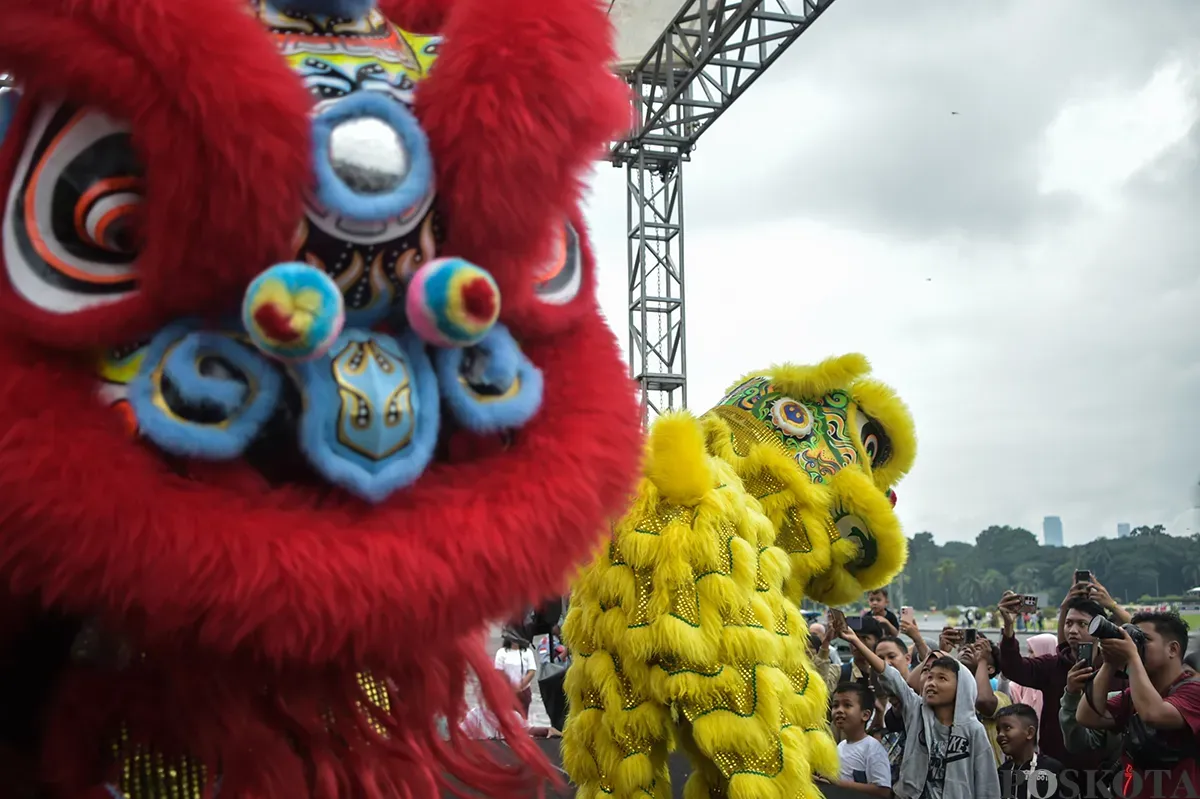 Pengunjung menyaksikan atraksi barongsai yang berlangsung di sisi utara Monumen Nasional (Monas), Jakarta, Selasa, 28 Januari 2025. (Sumber: Poskota/Bilal Nugraha Ginanjar)