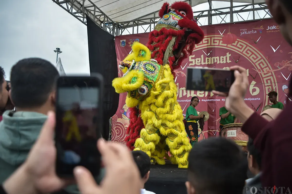 Pengunjung menyaksikan atraksi barongsai yang berlangsung di sisi utara Monumen Nasional (Monas), Jakarta, Selasa, 28 Januari 2025. (Sumber: Poskota/Bilal Nugraha Ginanjar)