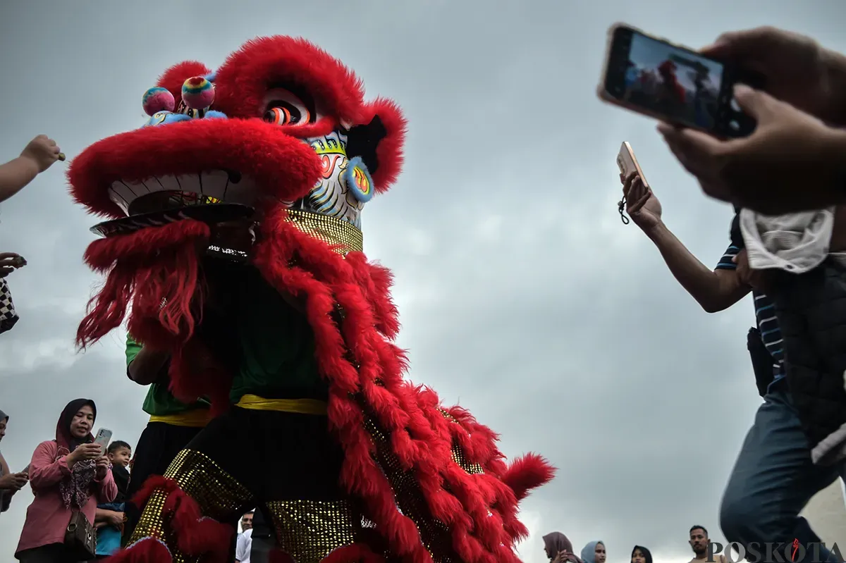 Pengunjung menyaksikan atraksi barongsai yang berlangsung di sisi utara Monumen Nasional (Monas), Jakarta, Selasa, 28 Januari 2025. (Sumber: Poskota/Bilal Nugraha Ginanjar)