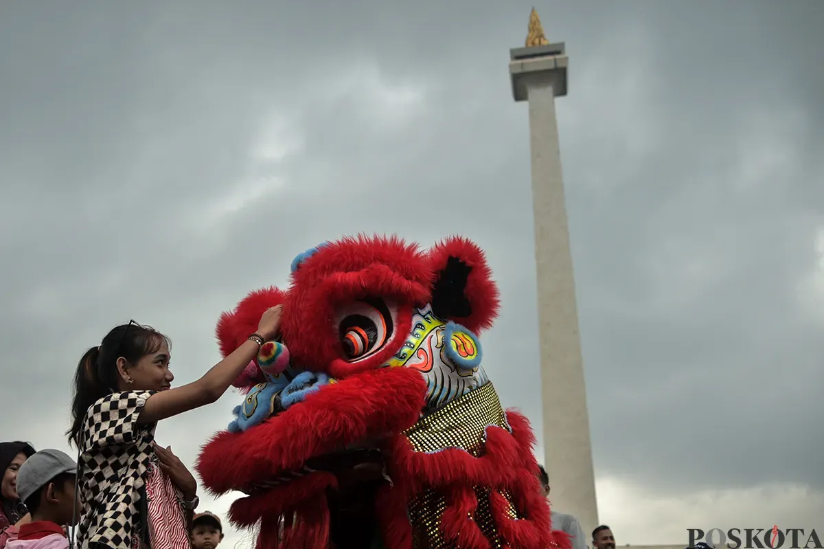 Pengunjung menyaksikan atraksi barongsai yang berlangsung di sisi utara Monumen Nasional (Monas), Jakarta, Selasa, 28 Januari 2025. (Sumber: Poskota/Bilal Nugraha Ginanjar)