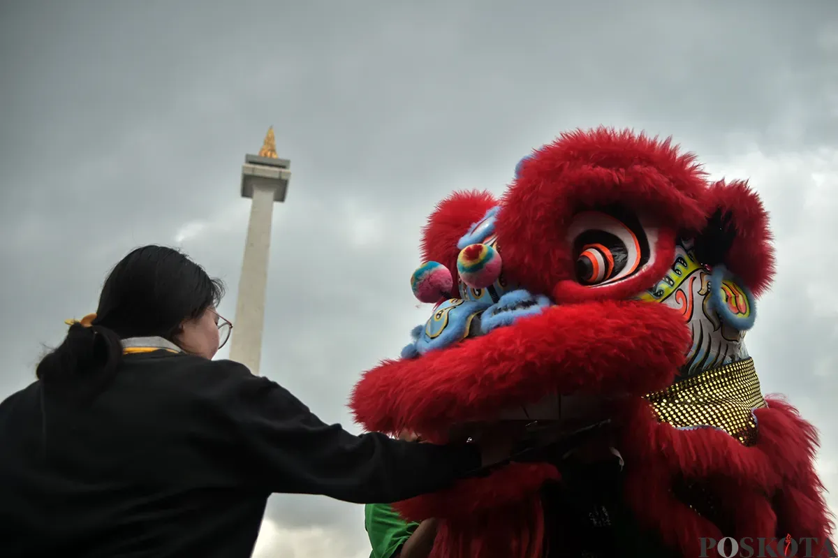 Pengunjung menyaksikan atraksi barongsai yang berlangsung di sisi utara Monumen Nasional (Monas), Jakarta, Selasa, 28 Januari 2025. (Sumber: Poskota/Bilal Nugraha Ginanjar)