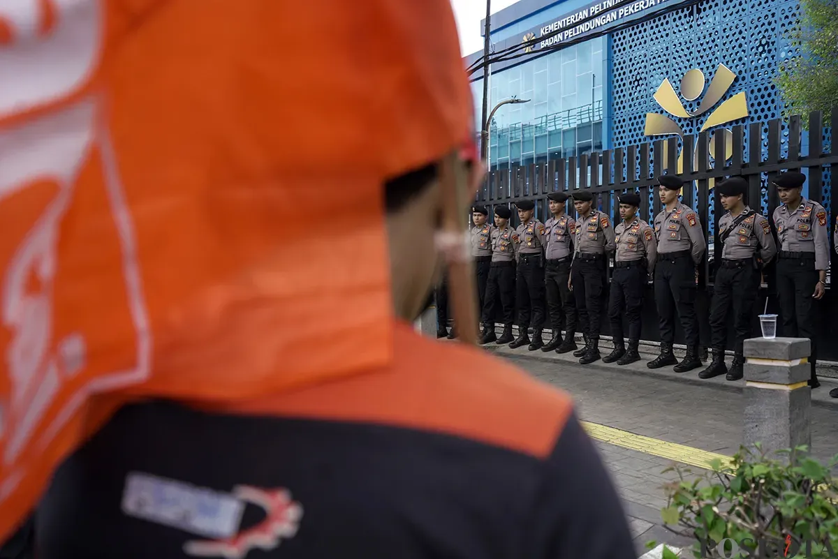 Pengunjuk rasa yang tergabung dalam Konfederasi Serikat Pekerja Indonesia (KSPI) dan Partai Buruh menggelar unjuk rasa terkait kasus penembakan buruh migran Indonesia oleh aparat di Malaysia, di depan Kantor Kementerian Perlindungan Pekerja Migran Indonesia (P2MI), Jalan MT Haryono, Jakarta Selatan, Kamis, 30 Januari 2025. (Sumber: Poskota/ Bilal Nugraha Ginanjar)