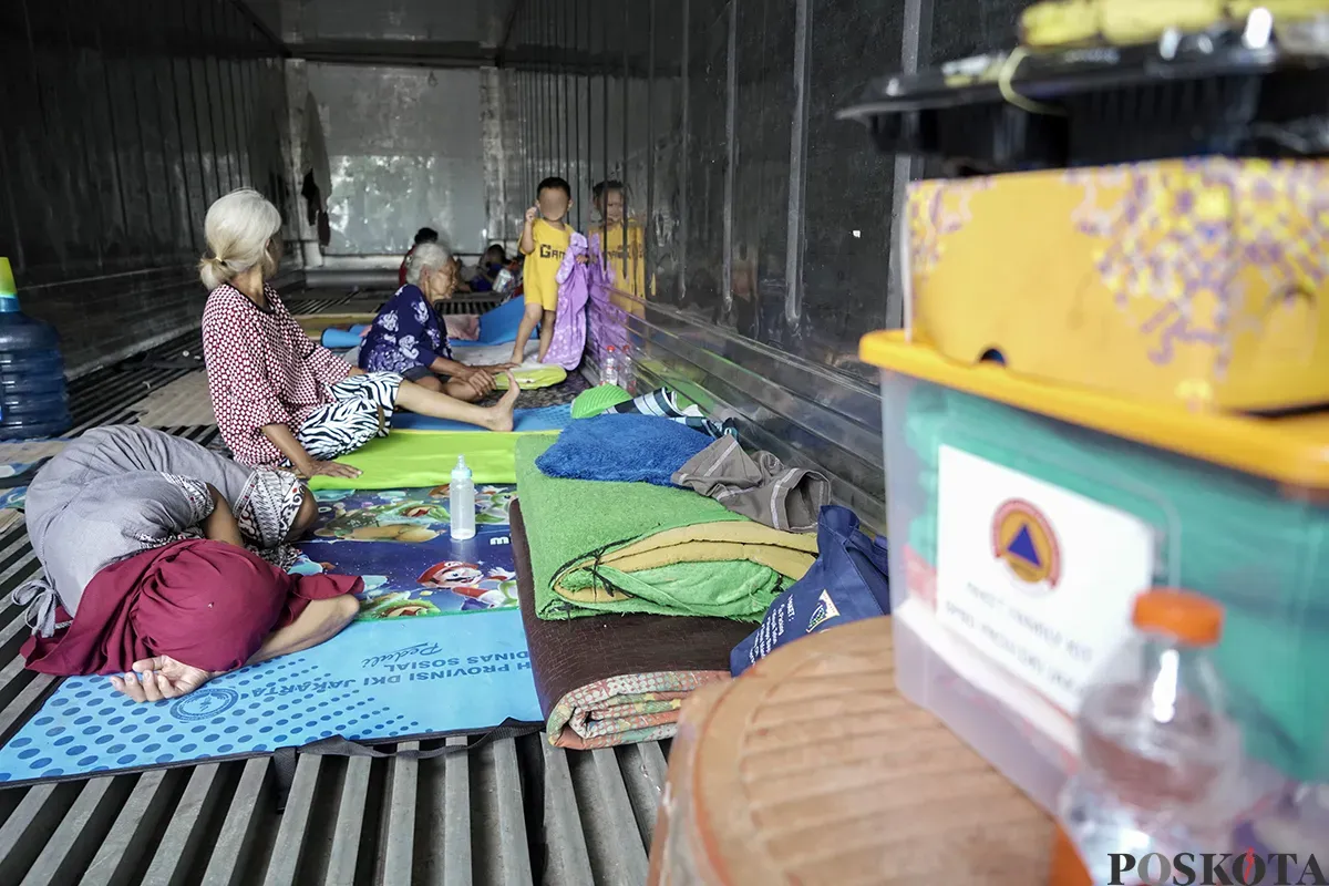 Sejumlah warga lanjut usia (lansia) dan keluarganya masih memilih bertahan di tempat pengungsian  di dalam peti kemas kosong lantaran rumahnya masih terendam banjir dalam beberapa hari terakhir di Kelurahan Rorotan, Cilincing, Jakarta Utara, Jumat, 31 Januari 2025. (Sumber: Poskota/Bilal Nugraha Ginanjar)