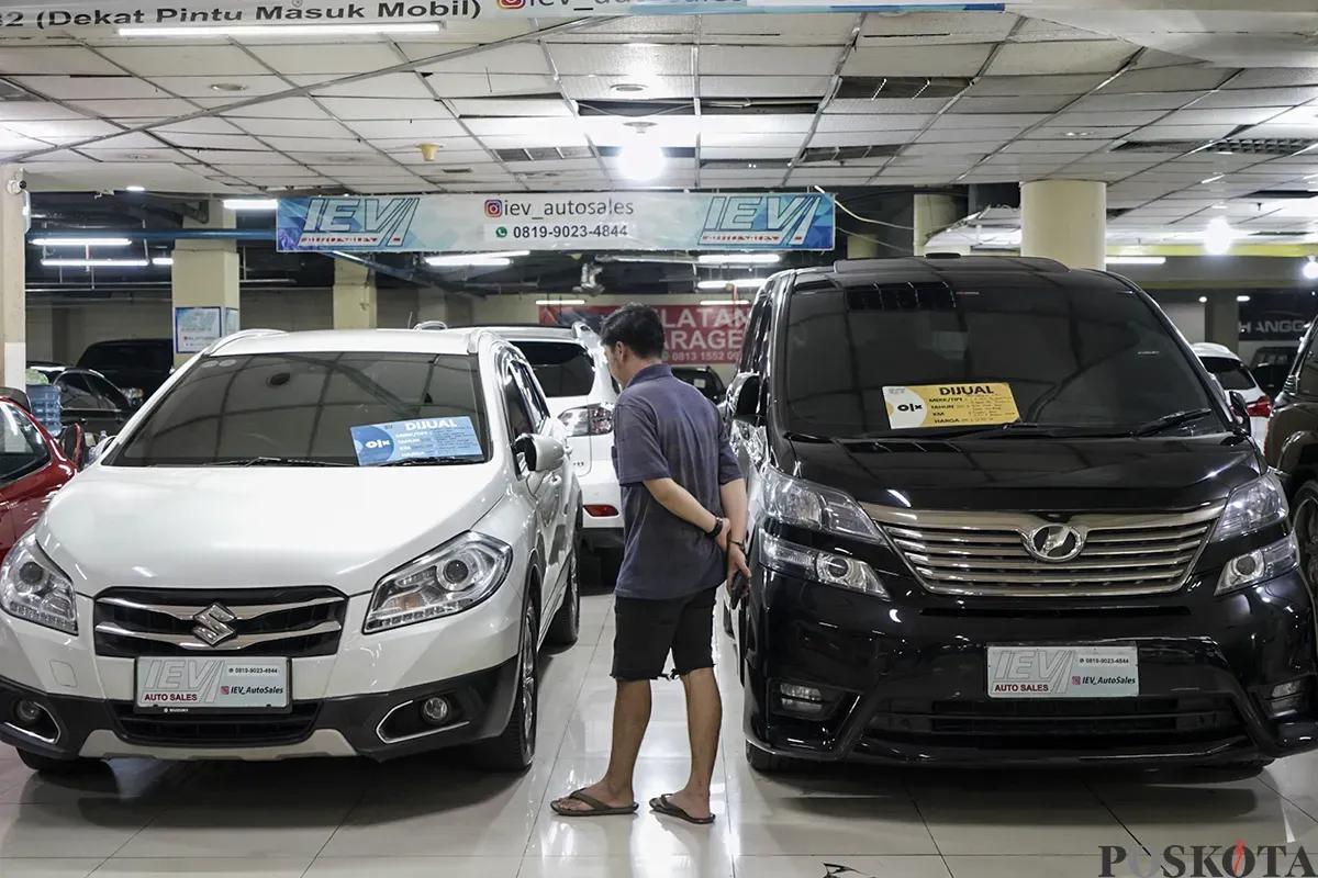 Pedagang mobil bekas, Prayudi, mengecek kondisi mobil bekas yang tampak terawat dan akan dijual di lapaknya di Bursa Mobil Bekas, Blok M, Jakarta Selatan, Jumat, 31 Januari 2025. (Sumber: Poskota/Bilal Nugraha Ginanjar)