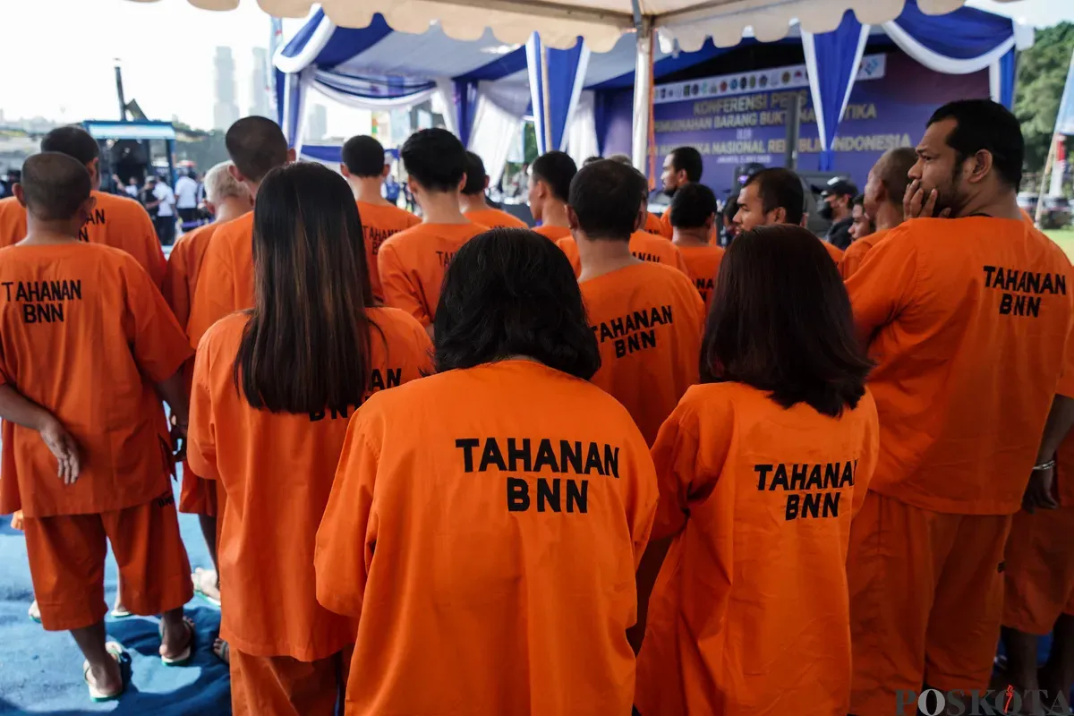 Tersangka tindak pidana narkoba dihadirkan dalam konferensi pers pemusnahan barang bukti narkoba di Lapangan Kampung Boncos, Jakarta, 2 Juli 2025. (Sumber: Poskota/Bilal Nugraha Ginanjar)