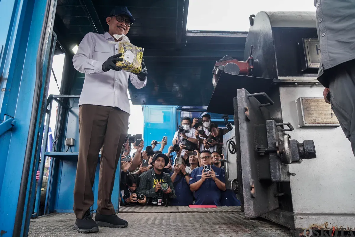 Menteri Perlindungan Pekerja Migran Indonesia (P2MI) Abdul Kadir Karding memasukan barang bukti narkotika jenis sabu ke dalam alat pembakar saat pemusnahan barang bukti narkotika di Lapangan Kampung Boncos, 2 Juli 2025. (Sumber: Poskota/Bilal Nugraha Ginanjar)