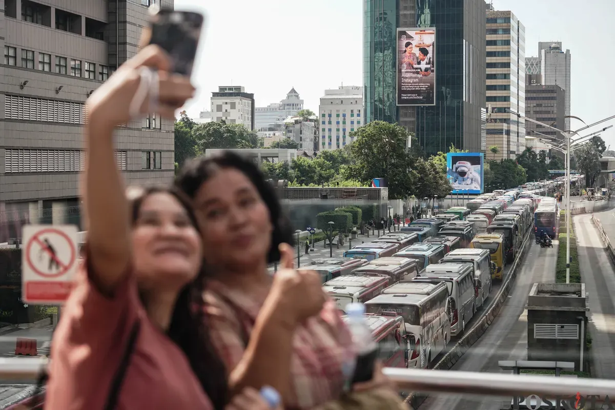 Sejumlah bus dan kendaraan bermotor memadati jalan lokasi acara perayaan HUT ke-79 Bhayangkara ke-79 di Jalan MH Thamrin dan Bundaran HI, Jakarta, Selasa, 1 Juli 2025. (Sumber: Poskota/Bilal Nugraha Ginanjar)
