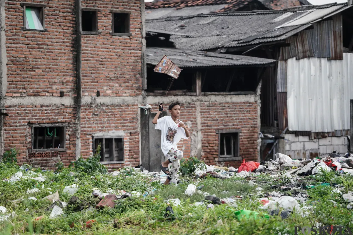 Anak-anak bermain layang-layang di lahan kosong, Kampung Boncos, Jakarta, 3 Juli 2025. (Sumber: Poskota/Bilal Nugraha Ginanjar)