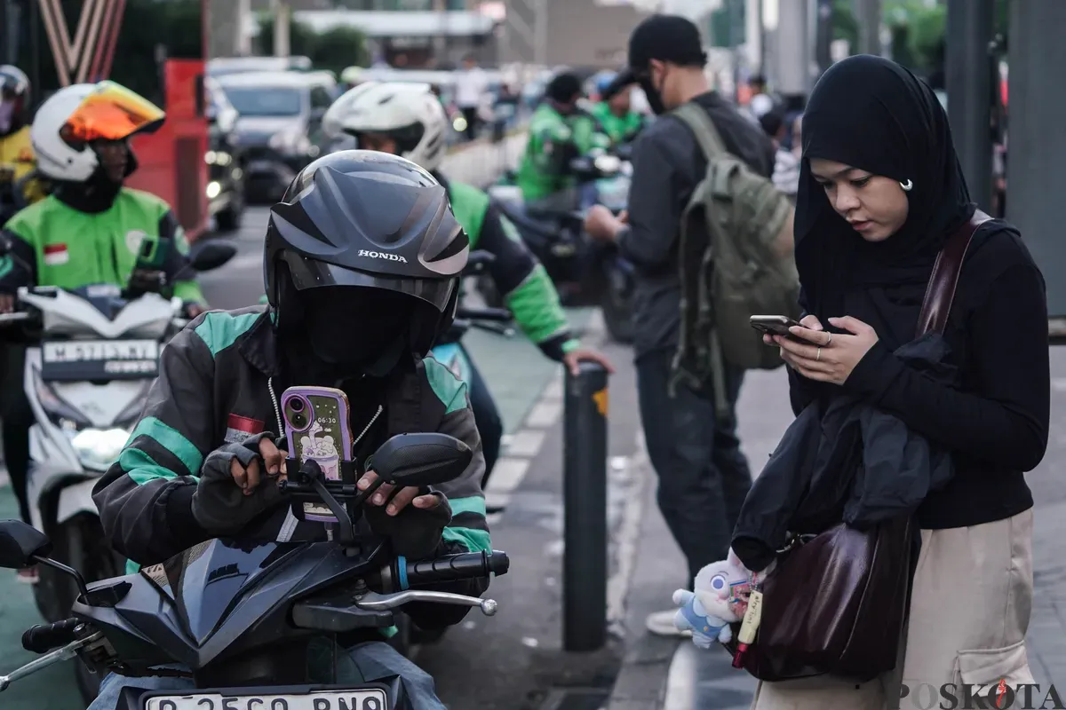 Pengemudi ojek daring dengan membawa penumpang melintas di Jalan MH Thamrin, Jakarta, Kamis, 3 Juli 2025. (Sumber: Poskota/Bilal Nugraha Ginanjar)