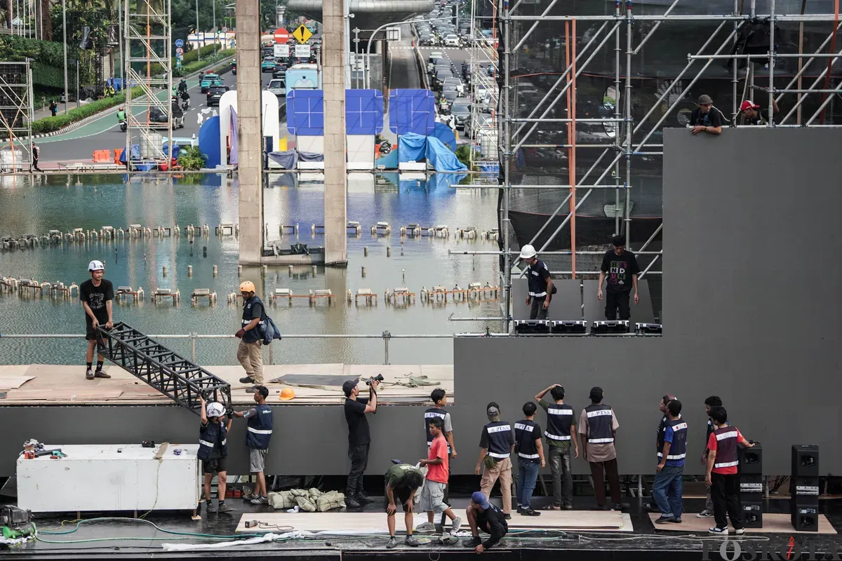 Para pekerja menyelesaikan pembangunan panggung di kawasan Bundaran Hotel Indonesia (HI), Jakarta, Jumat, 4 Juli 2025. (Sumber: Poskota/Bilal Nugraha Ginanjar)