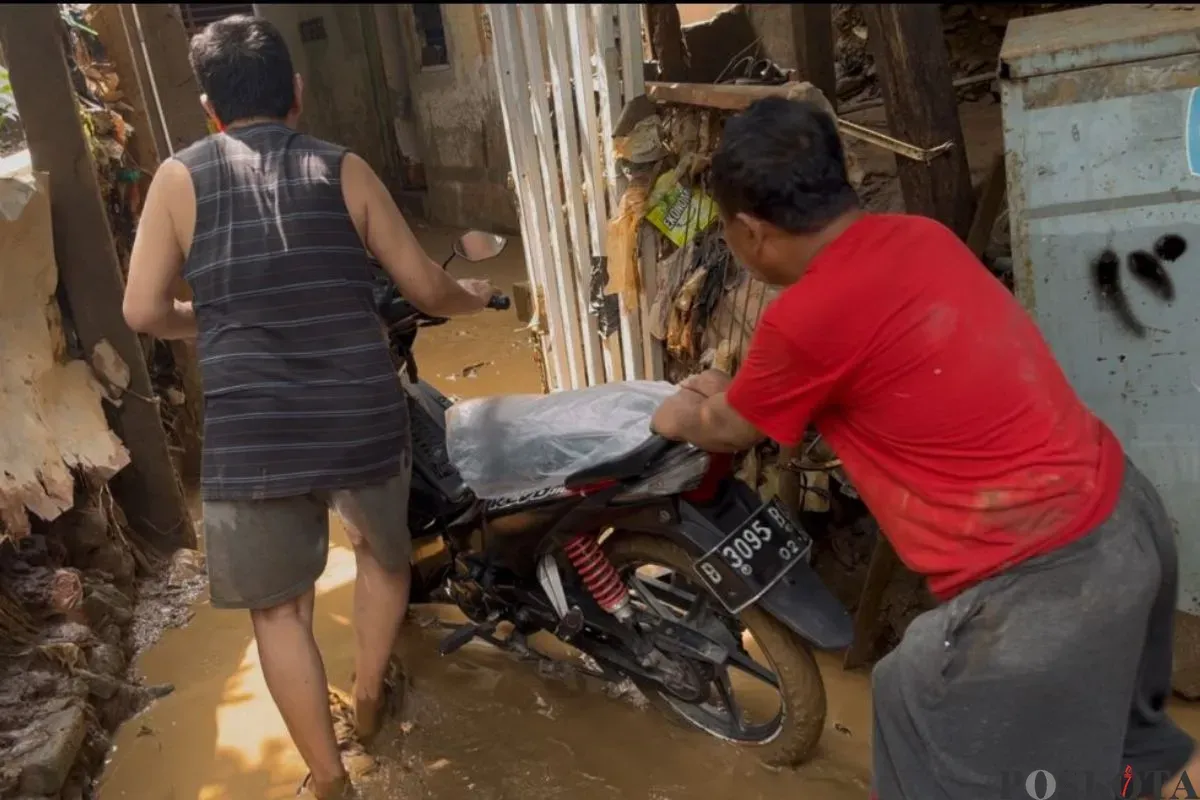 Warga mengeluarkan kendaraan seusai banjir surut dan hanya menyisakan kudapan lumpur di Bidara Cina, Jakarta Timur, Senin, 7 Juli, 2025. (Sumber: Poskota/M. Tegar Jihad)