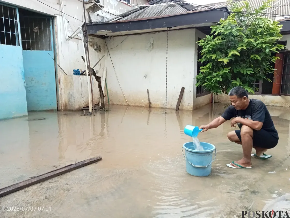 Himin, 52 tahun, Warga Kampung Lebak, Teluk Pucung, Kota Bekasi, berusaha membuang genangan air yang ada di luar rumahnya akibat banjir kiriman dari Bogor, Senin, 7 Juli 2025. (Sumber: Poskota/Nurpini Aulia Rapika)