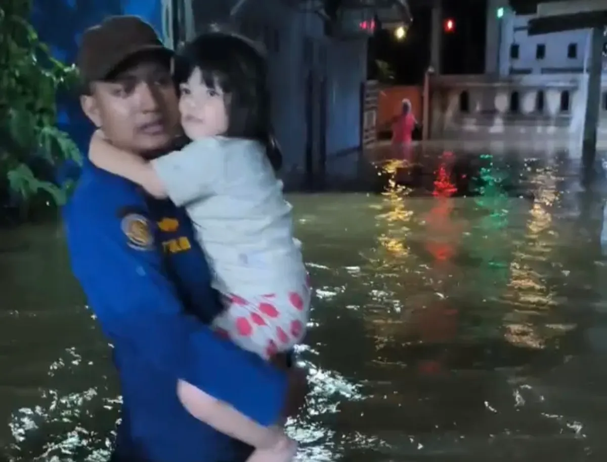 Petugas Damkar UPT Cimanggis mengevakuasi balita di tengah kepungan banjir akibat tanggul kali jebol di Perum Lembah Nirmala 1, Mekarsari, Cimanggis, Kota Depok, Minggu, 6 Juli 2025, malam. (Sumber: Damkar Depok)