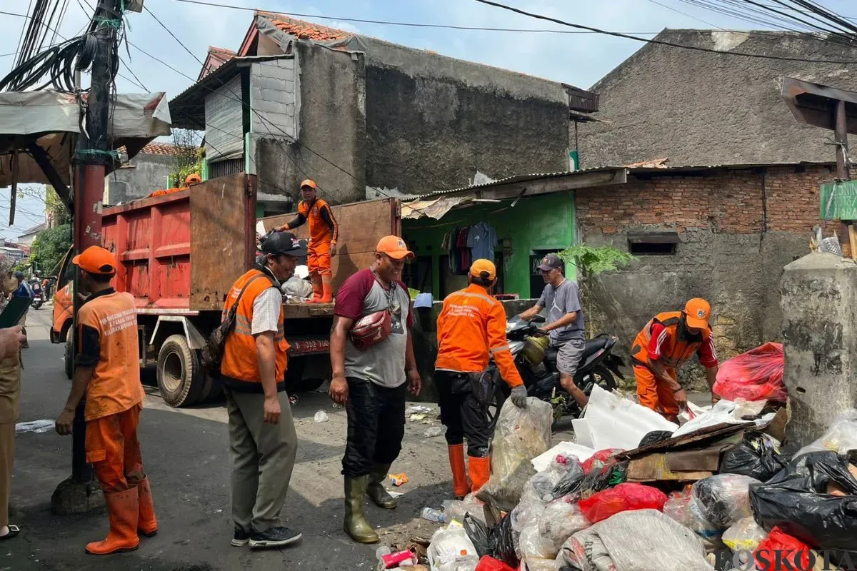 Sejumlah petugas UPS Badan Air sedang menangani sisa sampah banjir di Bidara Cina, Jakarta Timur, Senin, 7 Juli 2025. (Sumber: Poskota/M. Tegar Jihad)