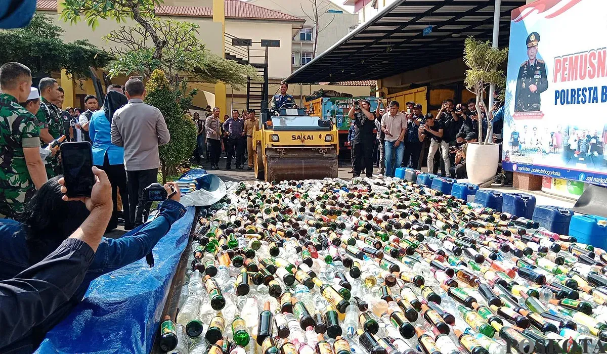 Polresta Bogor Kota bersama Forkopimda Kota Bogor memusnahkan 17 ribu botol miras hasil operasi tiga bulan terakhir di halaman Mako Polresta Bogor pada Selasa, 8 Juli 2025. (Sumber: POSKOTA | Foto: Sekar Putri Andini)