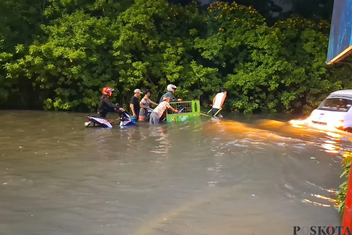 Warga di Kembangan Selatan, Kembangan, Jakbar, buka jasa sewa gerobak untuk pengendara motor yang mau menyebrangi banjir di ruas Jalan Ring Road, Selasa 8 Juli 2025. (Sumber: POSKOTA | Foto: Pandi Ramedhan)