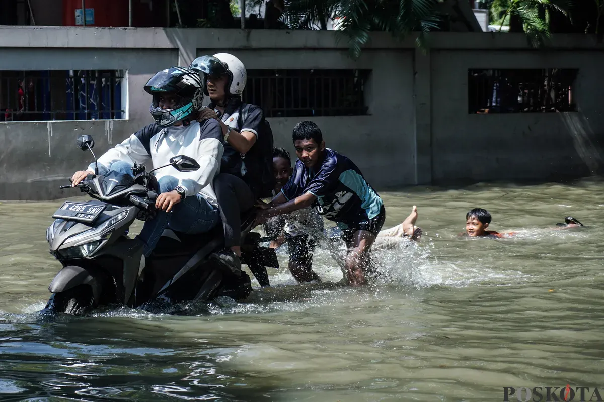 Pengendara sepeda motor melintasi banjir di Kampung Makasar, Jakarta Timur, Senin, 7 Juli 2025. (Sumber: Poskota/Bilal Nugraha Ginanjar)