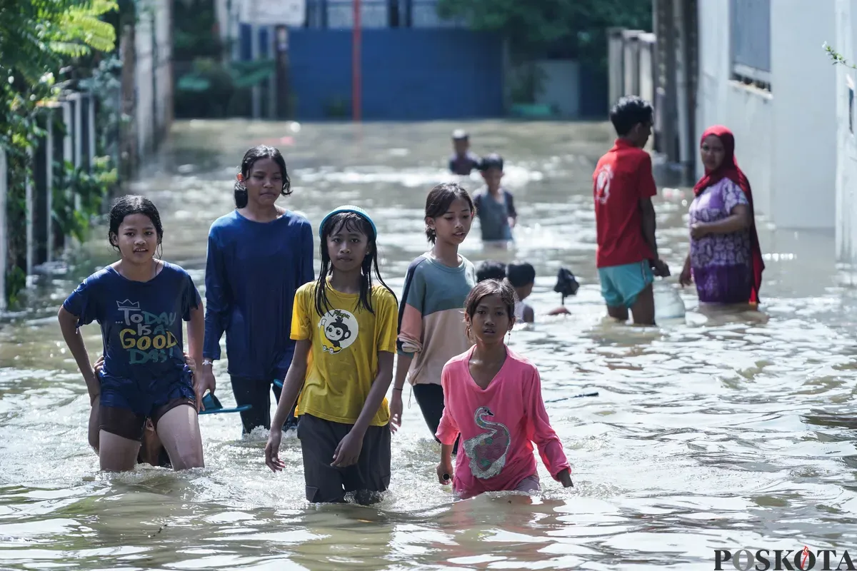 Anak-anak bermain di genagan air banjir di Kampung Makasar, Jakarta Timur, Senin, 7 Juli 2025. (Sumber: Poskota/Bilal Nugraha Ginanjar)