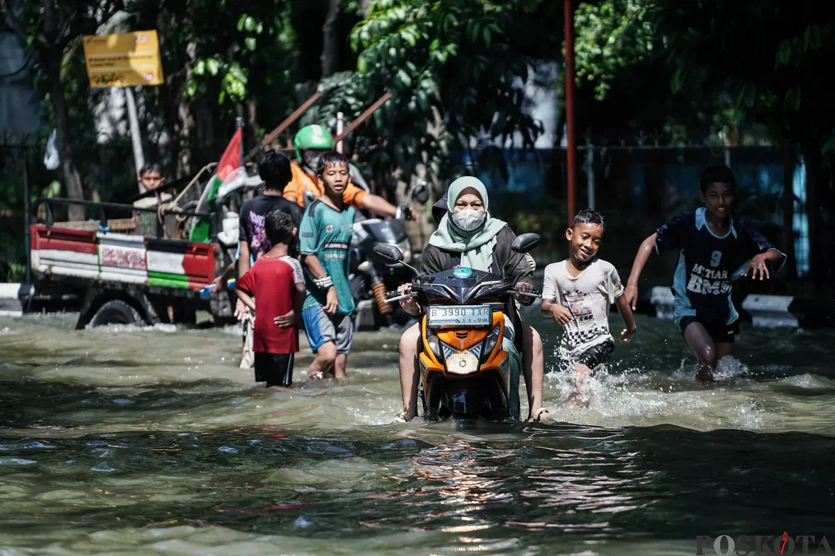 Pengendara sepeda motor melintasi banjir di Kampung Makasar, Jakarta Timur, Senin, 7 Juli 2025. (Sumber: Poskota/Bilal Nugraha Ginanjar)