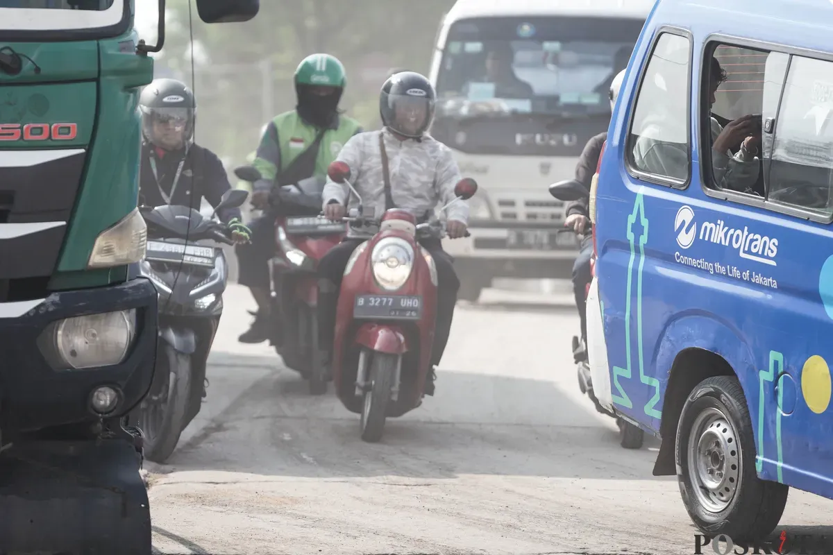 Pengendara melintas melewati jalanan berdebu di Jalan RE Martadinata, Tanjung Priok, Jakarta Utara, Senin, 7 Juli 2025. (Sumber: Poskota/Bilal Nugraha Ginanjar)