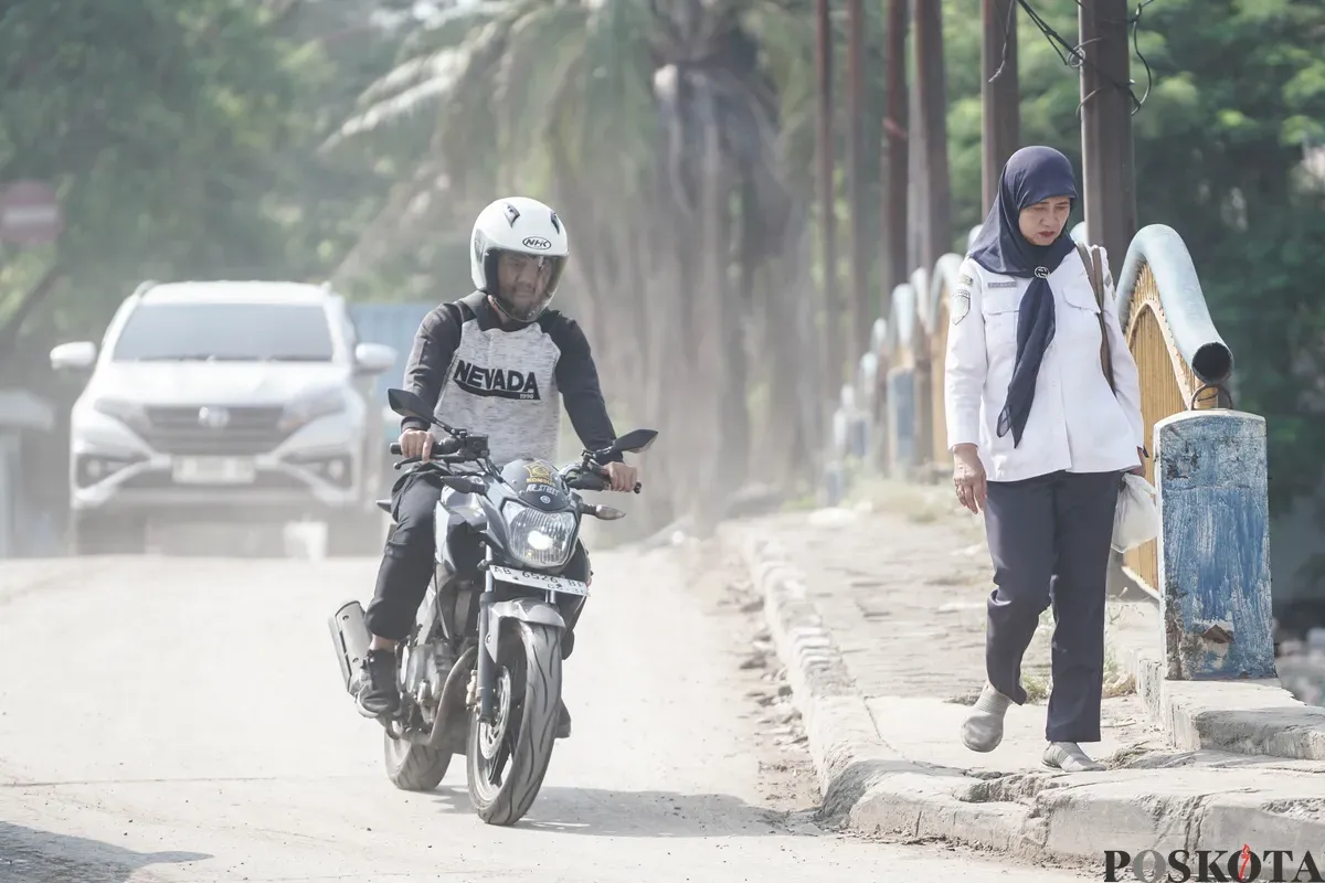 Pengendara melintas melewati jalanan berdebu di Jalan RE Martadinata, Tanjung Priok, Jakarta Utara, Senin, 7 Juli 2025. (Sumber: Poskota/Bilal Nugraha Ginanjar)