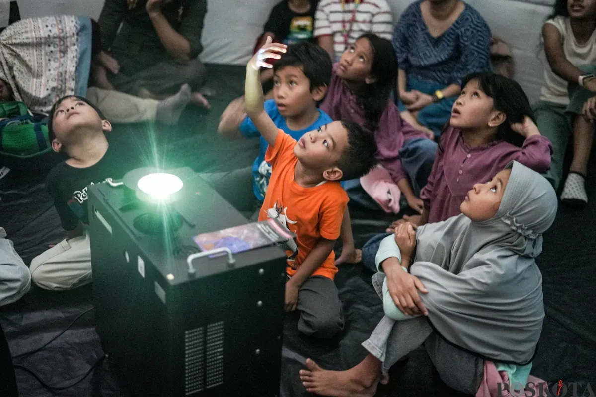 Anak-anak serta orang tuanya menyaksikan simulasi langit, serta penjelasan  seputar astronomi di planetarium mini yang berlokasi di kawasan Taman Ismail Marzuki, Jakarta, Selasa 8, Juli 2025. (Sumber: Poskota/Bilal Nugraha Ginanjar)