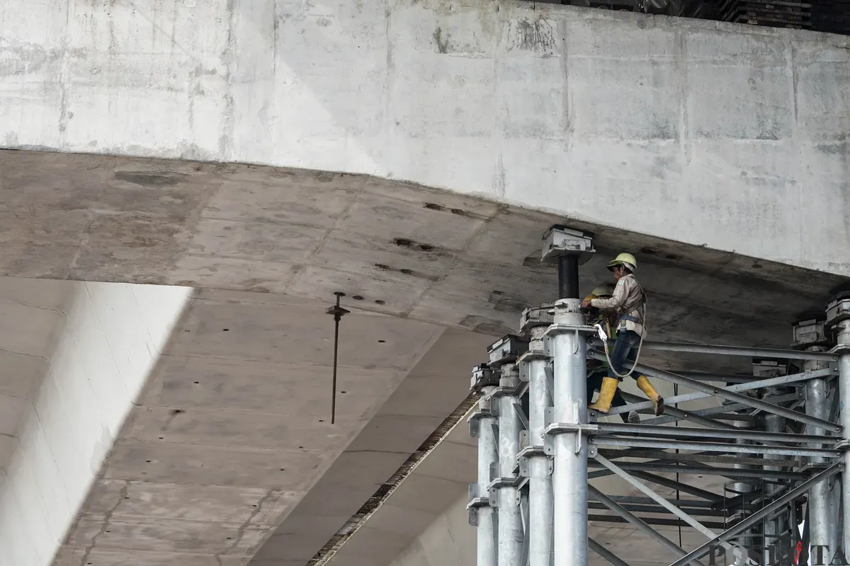 Sejumlah pekerja menyelesaikan pembangunan Jalan Tol Harbour Road II di Jalan Martadinata, Tanjung Priok, Jakarta Utara, Senin, 7 Juli 2025. (Sumber: Poskota/Bilal Nugraha Ginanjar)