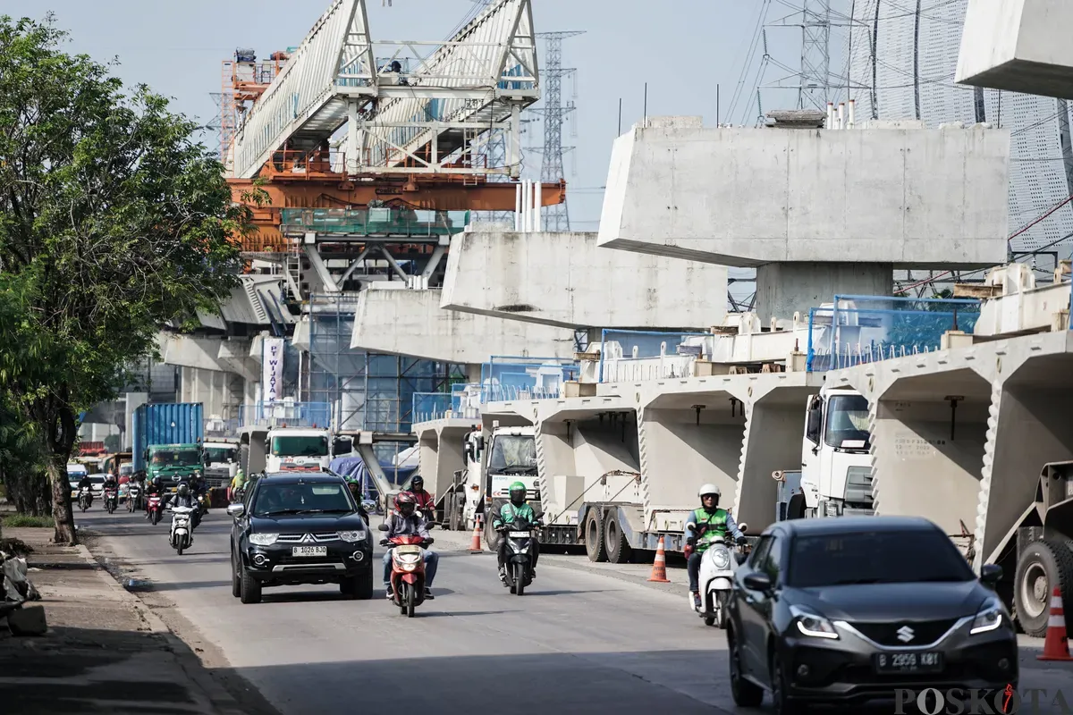 Sejumlah pekerja menyelesaikan pembangunan Jalan Tol Harbour Road II di Jalan Martadinata, Tanjung Priok, Jakarta Utara, Senin, 7 Juli 2025. (Sumber: Poskota/Bilal Nugraha Ginanjar)