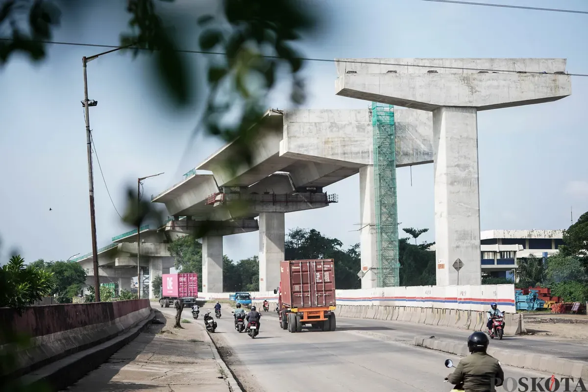 Sejumlah pekerja menyelesaikan pembangunan Jalan Tol Harbour Road II di Jalan Martadinata, Tanjung Priok, Jakarta Utara, Senin, 7 Juli 2025. (Sumber: Poskota/Bilal Nugraha Ginanjar)