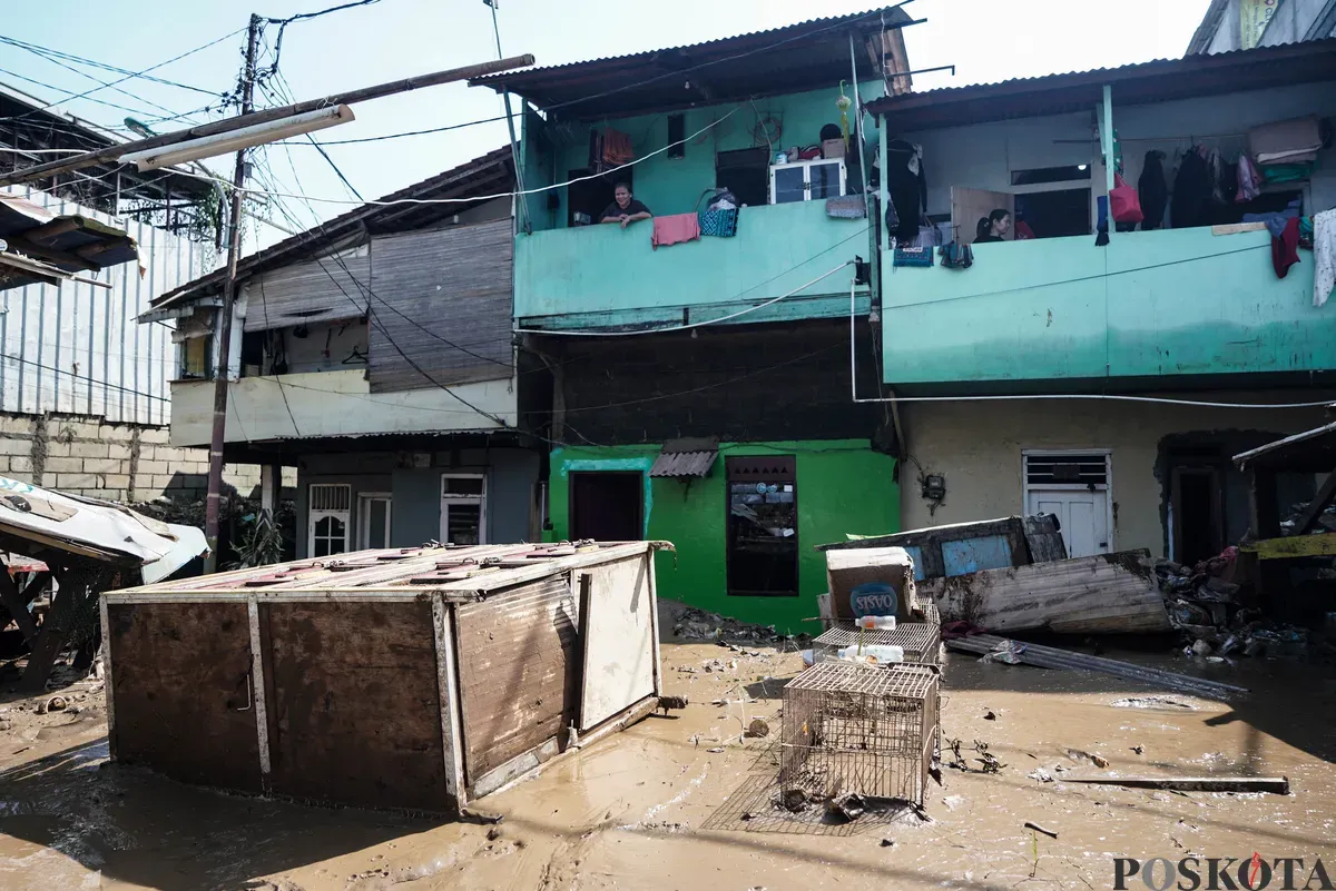 Warga membersihkan sisa sisa lumpur banjir di kawasan pemukiman Rawajati, Pancoran, Jakarta Selatan, Minggu, 7 Juli 2025. (Sumber: Poskota/Bilal Nugraha Ginanjar)
