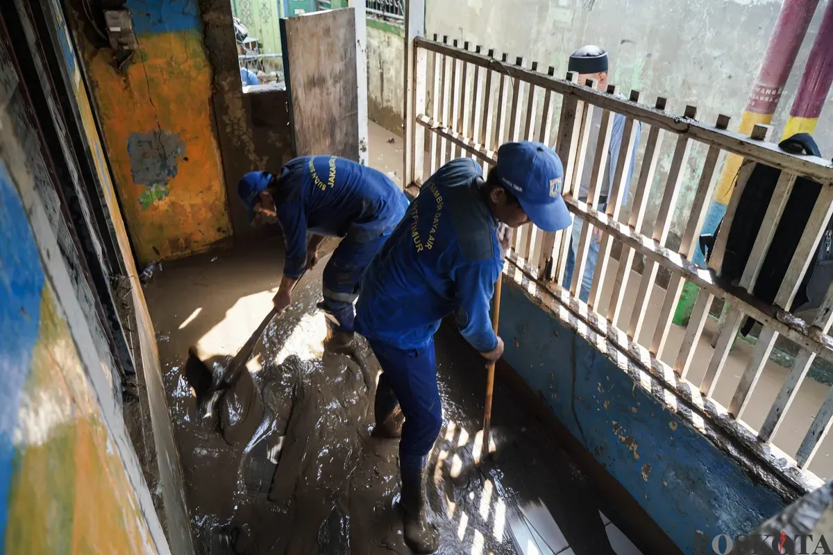 Warga membersihkan sisa sisa lumpur banjir di kawasan pemukiman Rawajati, Pancoran, Jakarta Selatan, Minggu, 7 Juli 2025. (Sumber: Poskota/Bilal Nugraha Ginanjar)