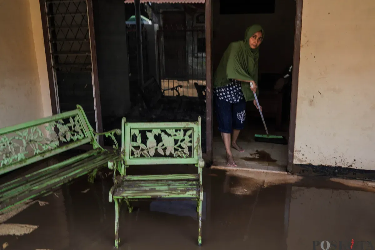 Warga membersihkan sisa sisa lumpur banjir di kawasan pemukiman Rawajati, Pancoran, Jakarta Selatan, Minggu, 7 Juli 2025. (Sumber: Poskota/Bilal Nugraha Ginanjar)