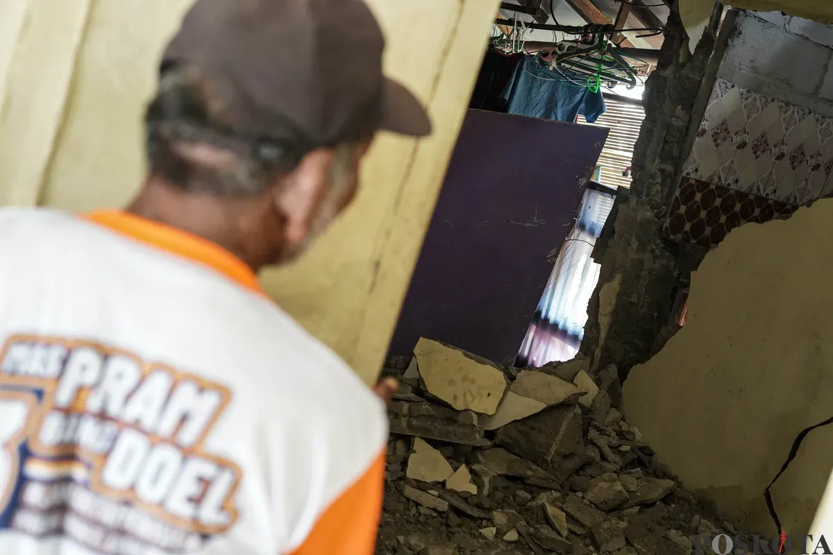 Warga melihat kondisi rumahnya yang mengalami longsor di bantaran Sungai Ciliwung di Jalan Slamet Riyadi I, Kebon Manggis, Matraman, Jakarta Timur, Kamis, 10 Juli 2025. (Sumber: Poskota/Bilal Nugraha Ginanjar)