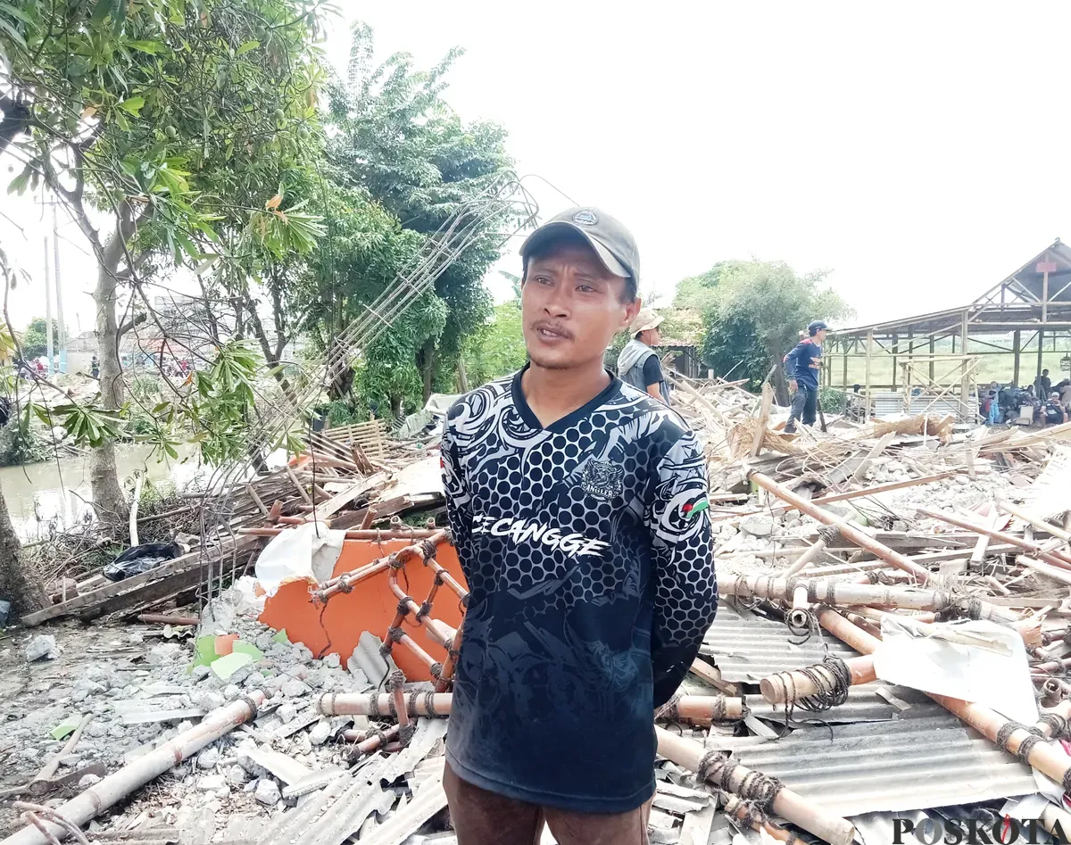 Muhammad Suhendra, 35 tahun, pemilik warung legendaris Gabus Pucung Betawi berdiri di tempat usahanya yang kini telah rata dengan tanah usai digusur karena berdiri di atas lahan pemerintah. (Sumber: Poskota/Nurpini Aulia Rapika)