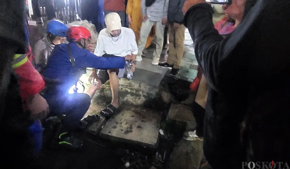 Petugas Damkar Kota Bogor mengevakuasi warga yang kakinya terjepit di rel kereta Stasiun Bogor, Minggu malam, 13 Juli 2025. (Sumber: POSKOTA | Foto: Sekar Putri Andini)