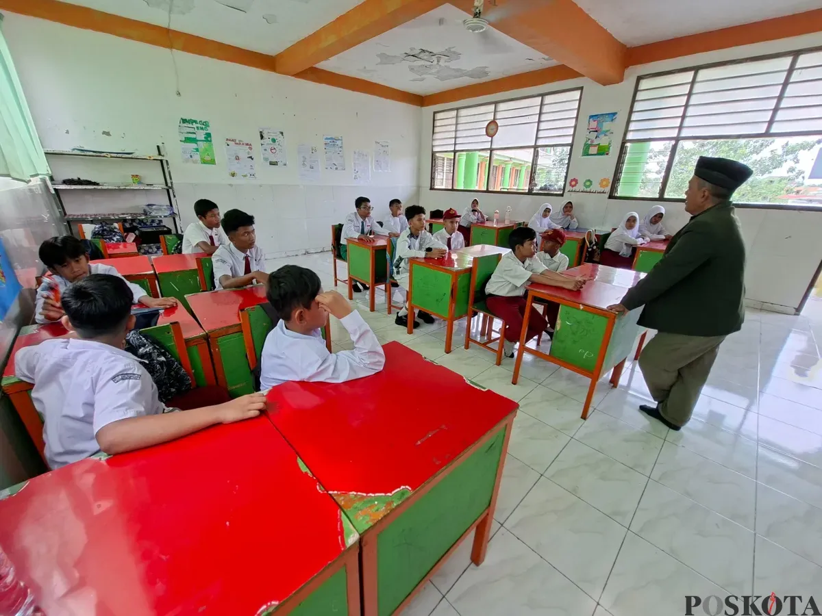 Direktur Sekolah AMEC, H.Mamun Ibnu Ridwan memberikan pemaparan pada 25 murid SMP rintisan gratis dalam kelas, Senin, 14 Juli 2025. (Sumber: Poskota/Angga Pahlevi)