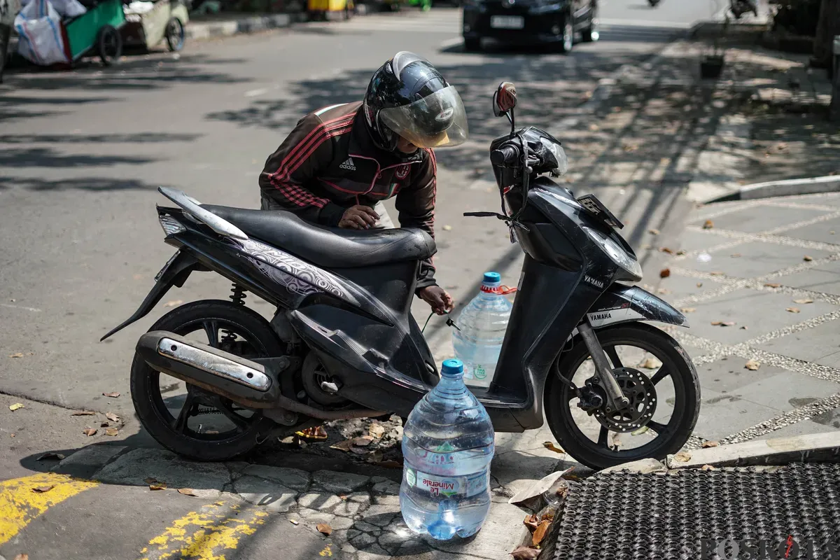 Warga mengisi botol air galon di depot air minum gratis di Jalan Rawamangun Muka Selatan, Jakarta Timur, Selasa, 15 Juli 2025. (Sumber: Poskota/Bilal Nugraha Ginanjar)