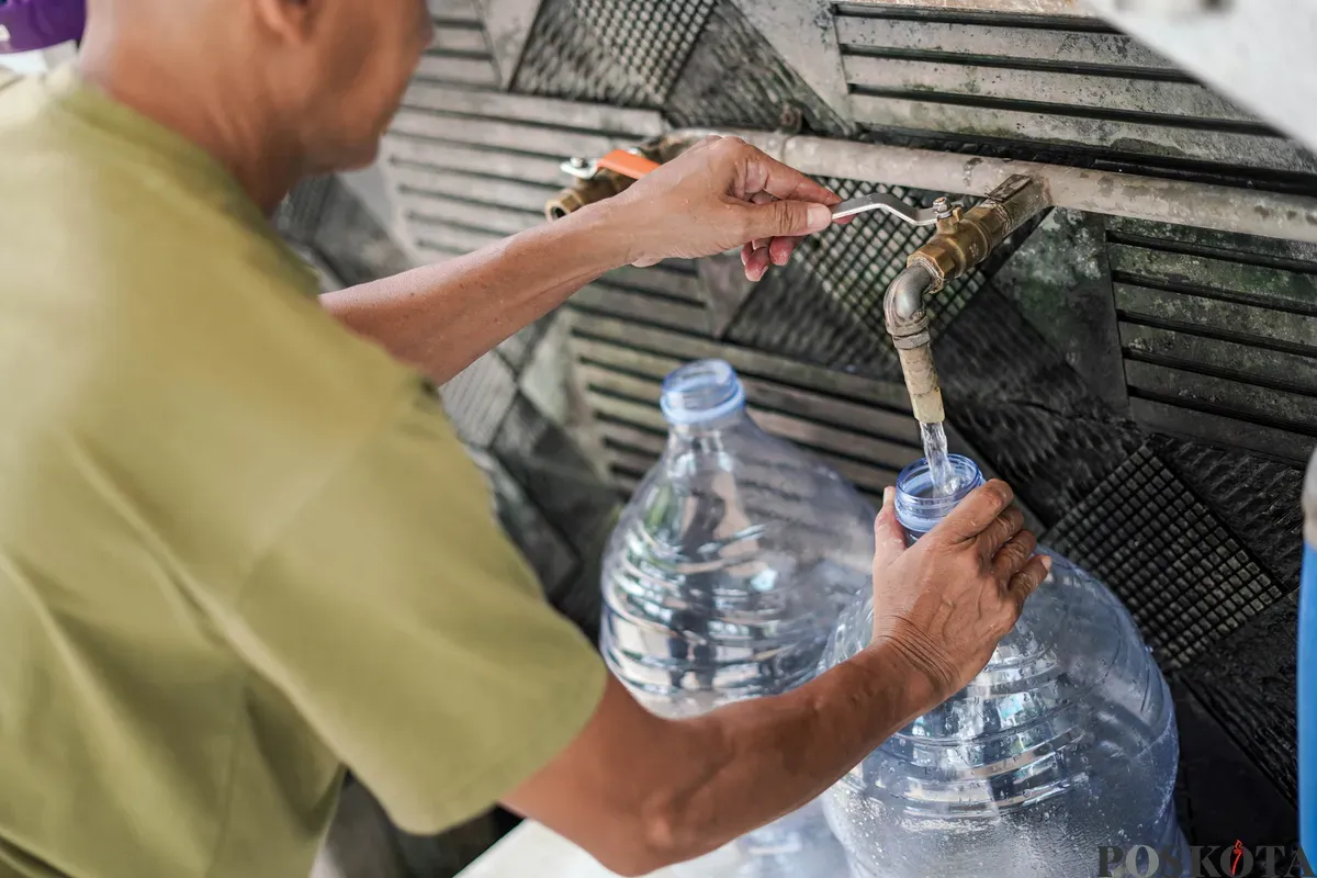 Warga mengisi botol air galon di depot air minum gratis di Jalan Rawamangun Muka Selatan, Jakarta Timur, Selasa, 15 Juli 2025. (Sumber: Poskota/Bilal Nugraha Ginanjar)