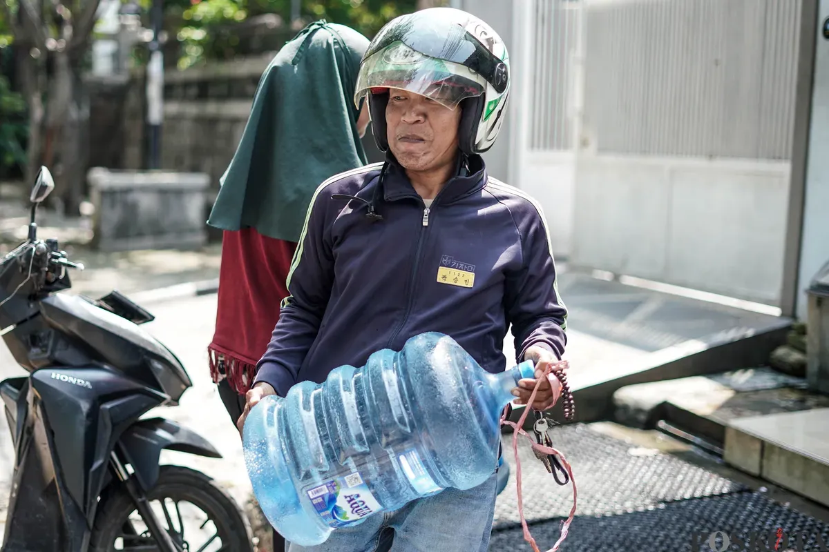 Warga mengisi botol air galon di depot air minum gratis di Jalan Rawamangun Muka Selatan, Jakarta Timur, Selasa, 15 Juli 2025. (Sumber: Poskota/Bilal Nugraha Ginanjar)