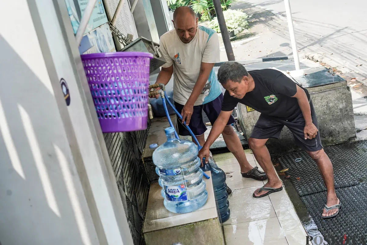 Warga mengisi botol air galon di depot air minum gratis di Jalan Rawamangun Muka Selatan, Jakarta Timur, Selasa, 15 Juli 2025. (Sumber: Poskota/Bilal Nugraha Ginanjar)