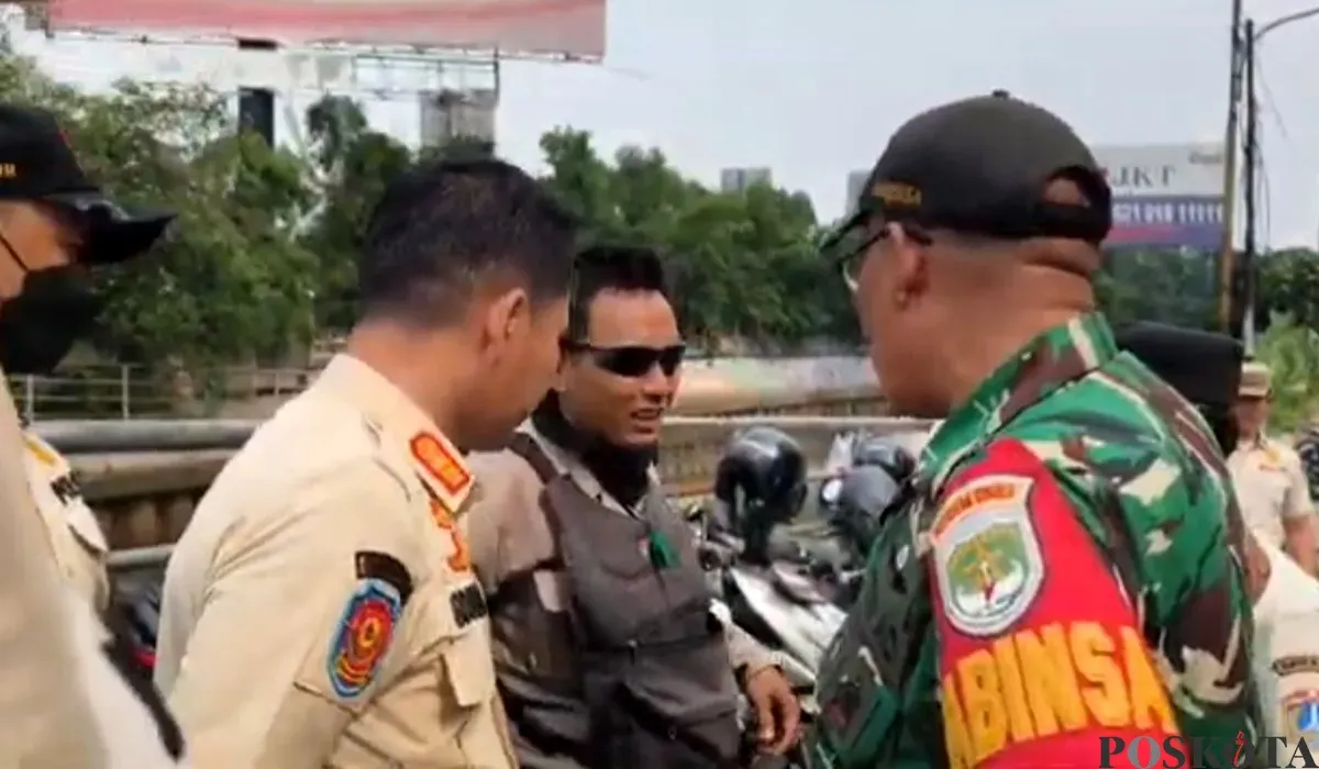 Seorang juru parkir liar di kawasan Mall Taman Anggrek Jakbar, ditegur petugas karena memakai baret TNI saat razia parkir liar. (Sumber: POSKOTA | Foto: Pandi Ramedhan)