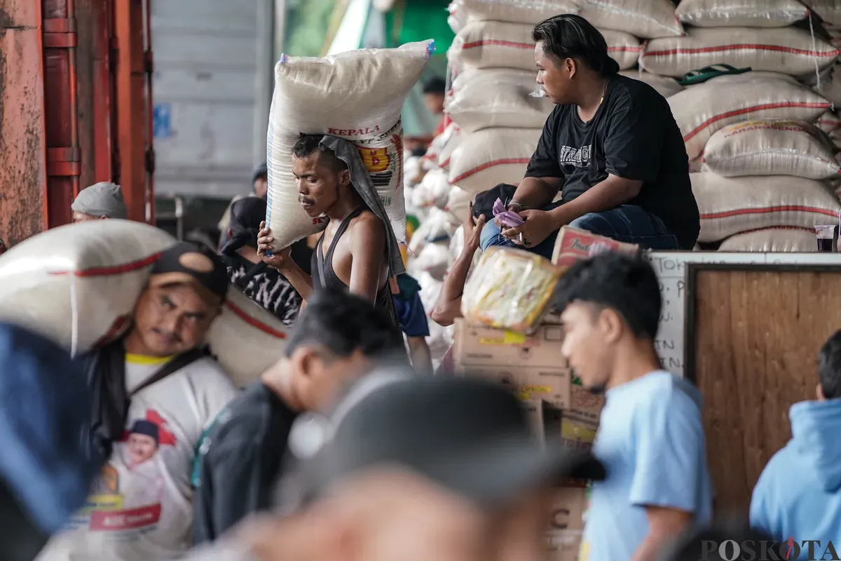 Pekerja mengangkat karung beras di Pasar Beras Cipinang, Jakarta Timur, Selasa, 15 Juli 2025. (Sumber: Poskota/Bilal Nugraha Ginanjar)