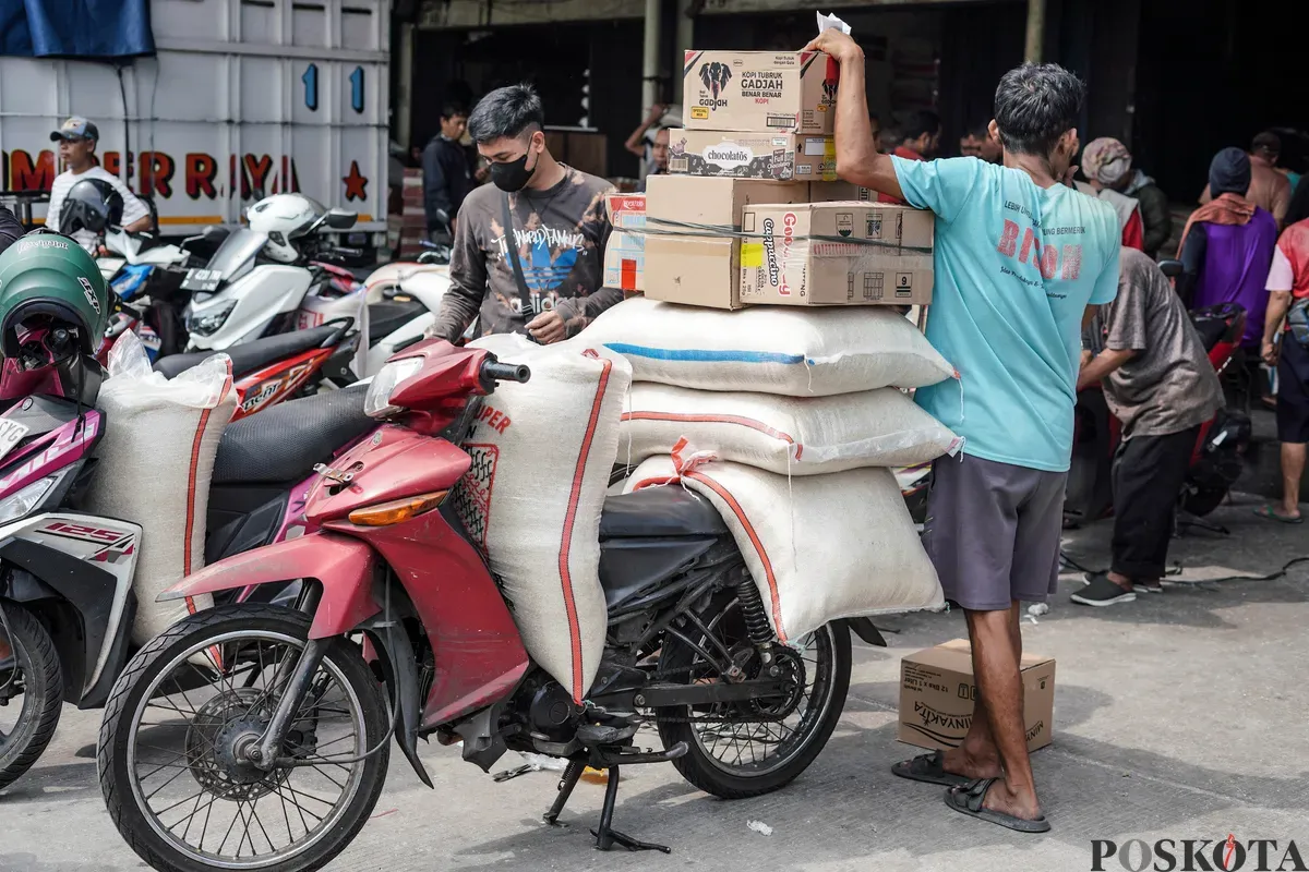 Pekerja mengangkat karung beras di Pasar Beras Cipinang, Jakarta Timur, Selasa, 15 Juli 2025. (Sumber: Poskota/Bilal Nugraha Ginanjar)