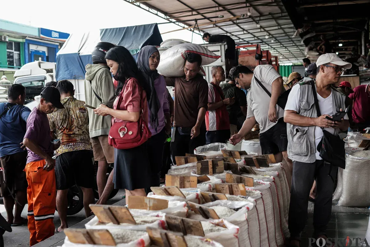 Pekerja mengangkat karung beras di Pasar Beras Cipinang, Jakarta Timur, Selasa, 15 Juli 2025. (Sumber: Poskota/Bilal Nugraha Ginanjar)
