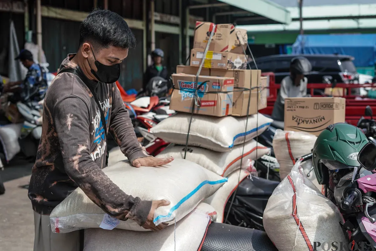 Pekerja mengangkat karung beras di Pasar Beras Cipinang, Jakarta Timur, Selasa, 15 Juli 2025. (Sumber: Poskota/Bilal Nugraha Ginanjar)