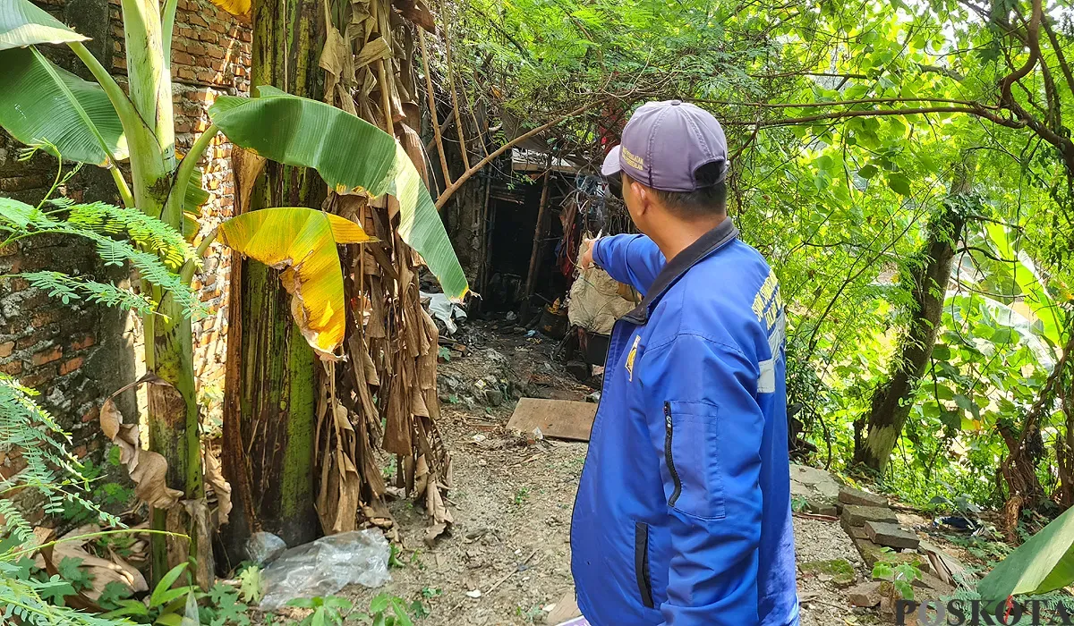 Warga menunjukkan lokasi penemuan jasad laki-laki yang sudah membusuk di sebuah gubuk di bantaran aliran Kali Pesanggrahan, Jakbar, Sabtu, 19 Juli 2025. (Sumber: POSKOTA | Foto: Pandi Ramedhan)